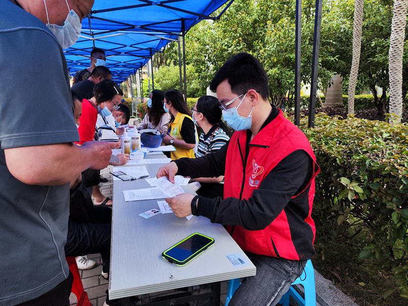 圖為市委外辦黨員志愿者協(xié)助做好疫苗接種信息登記.jpg